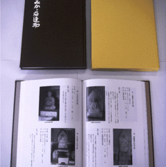 「とみかの石造物」黒い表紙の暑い本に白い文字、右に山吹色の本入れ箱、下に本を開いた中身に石仏の写真と文章などが写っている写真